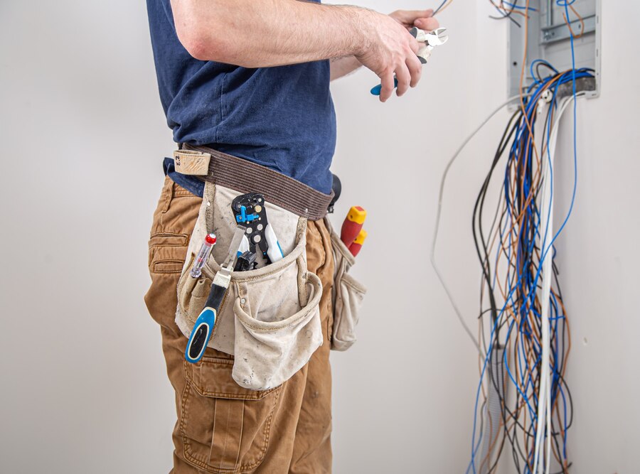 electrician builder work examines cable connection electrical line fuselage industrial switchboard professional overalls with electrician s tool_169016 8831